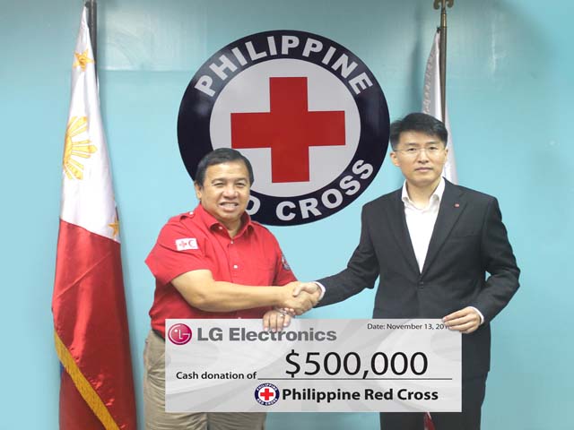 LG Electronics Philippines managing director Sung Woo Nam (right) presents $500,000 check to Philippine Red Cross chairman and chief executive officer Richard Gordon (left) signifying support to victims of super typhoon Yolanda